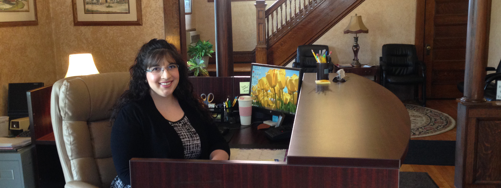 a smiling secretary sitting at a desk